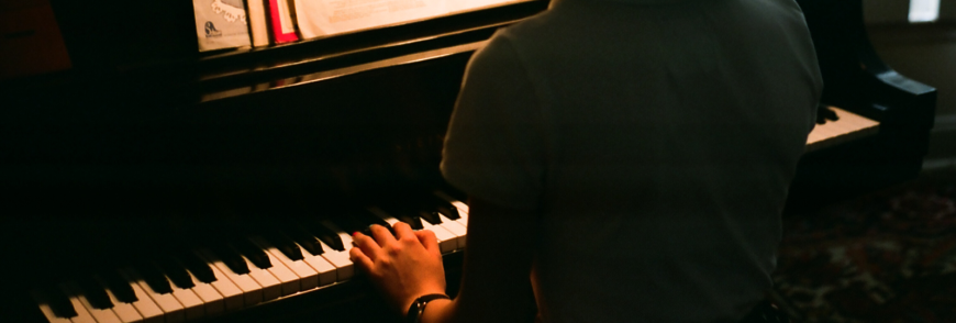 Girl with hands resting on piano