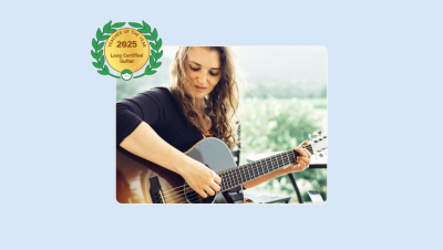 Image of Gina Sobel playing her guitar with her Teacher of the Year for Loog Certified Guitar badge