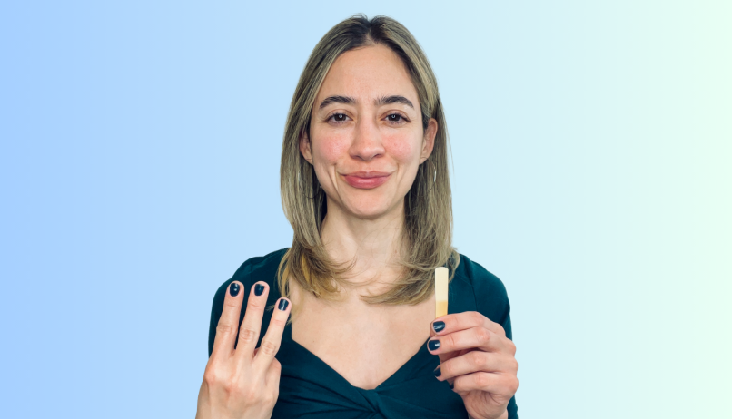 Image of Liz Ramirez holding the number 3 and a clarinet reed