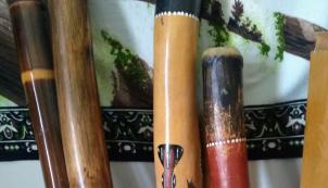 Four didgeridoos with decorative inlayed artwork.