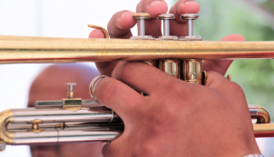 Close up of trumpet player's hands on instrument.
